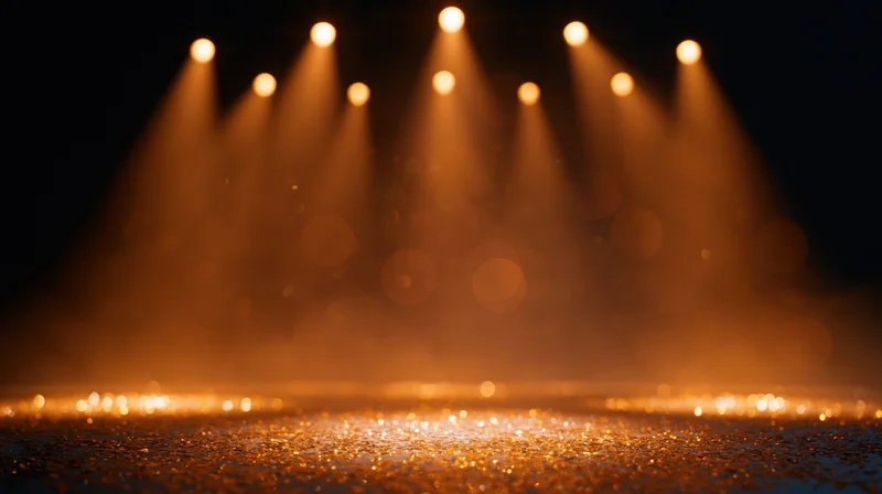 Stage lit by warm spotlights with glittering floor and hazy atmosphere