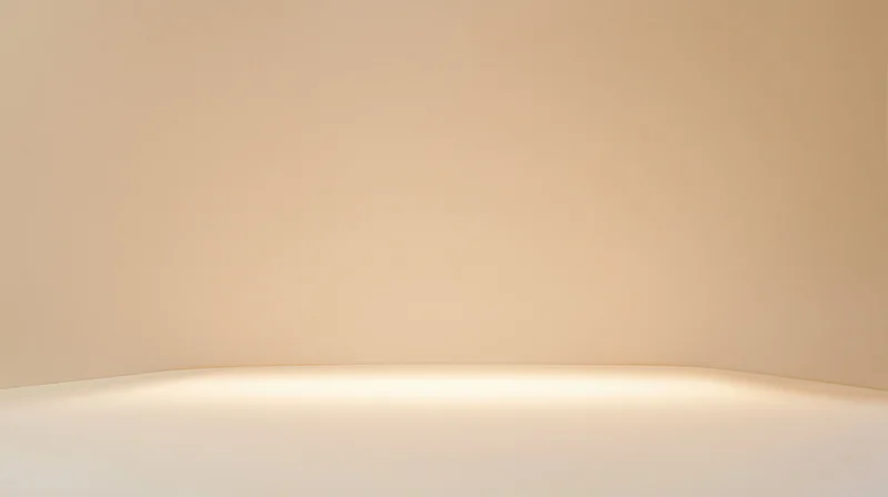 Curved beige studio wall and floor with soft warm lighting and copyspace