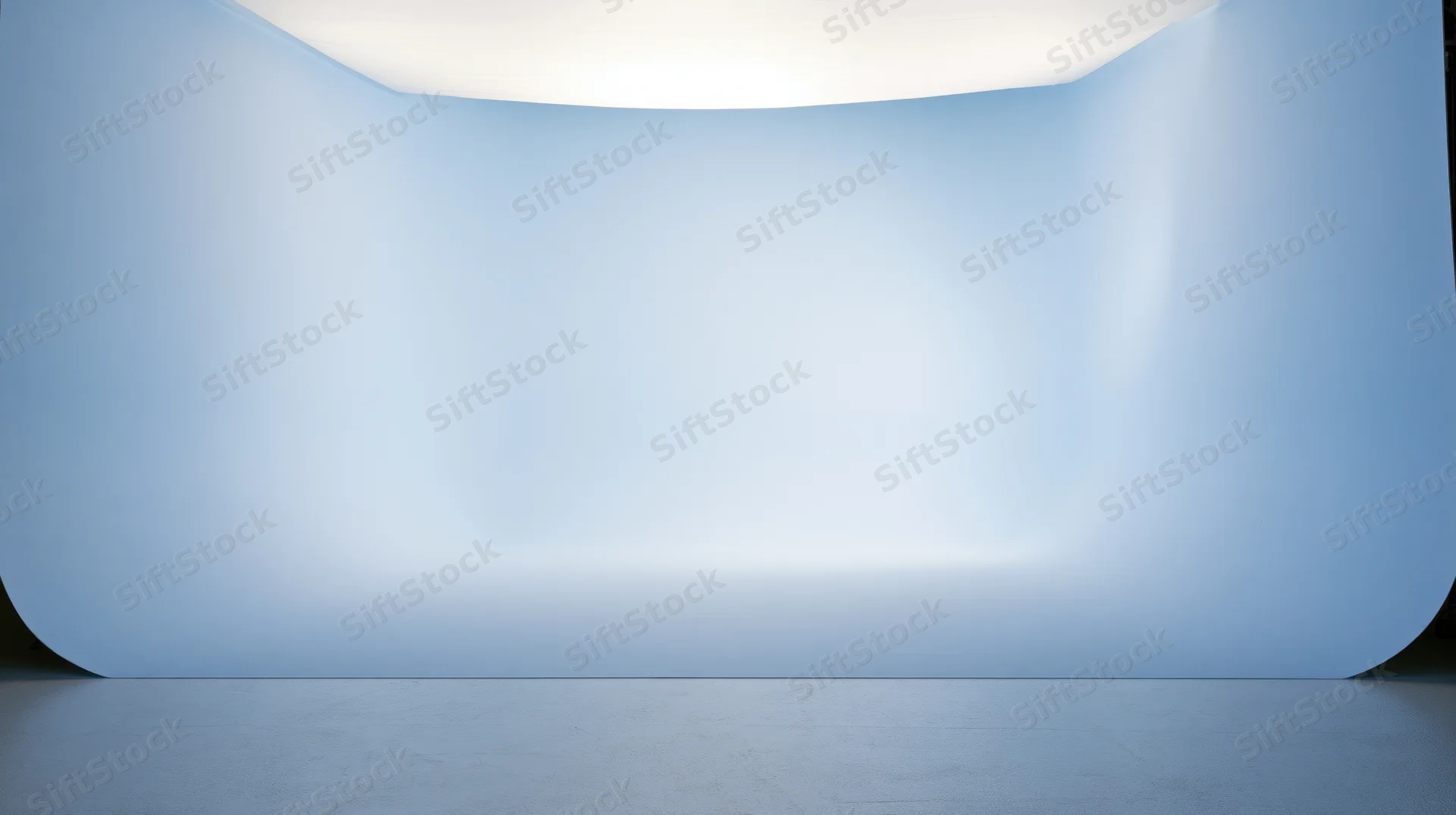 Curved blue gradient backdrop in a studio space with smooth surface and soft lighting