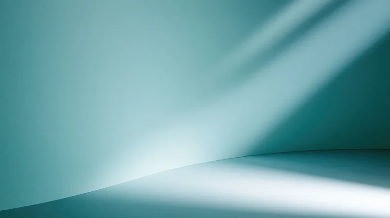 Smooth teal gradient background with soft light and shadow curves in a studio corner