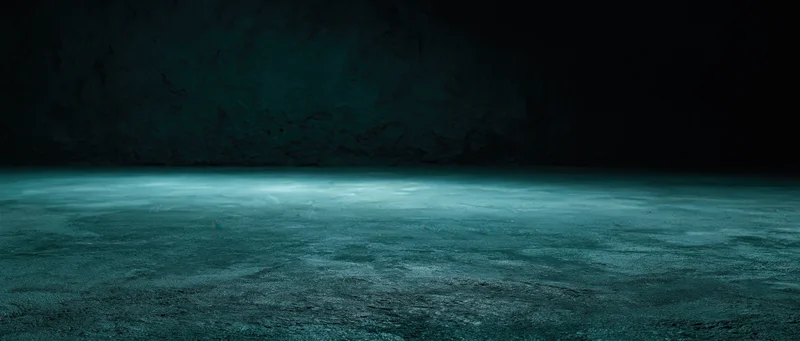 Dark teal textured floor in a cave-like underground space with dim ambient lighting and copyspace