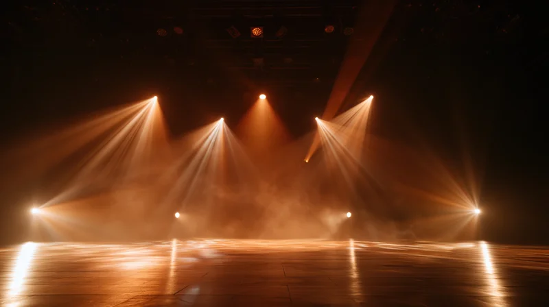 Stage lit by warm spotlights with haze and reflections on polished wooden floor