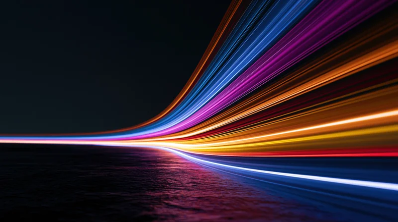Colorful light trails curving over dark water at night