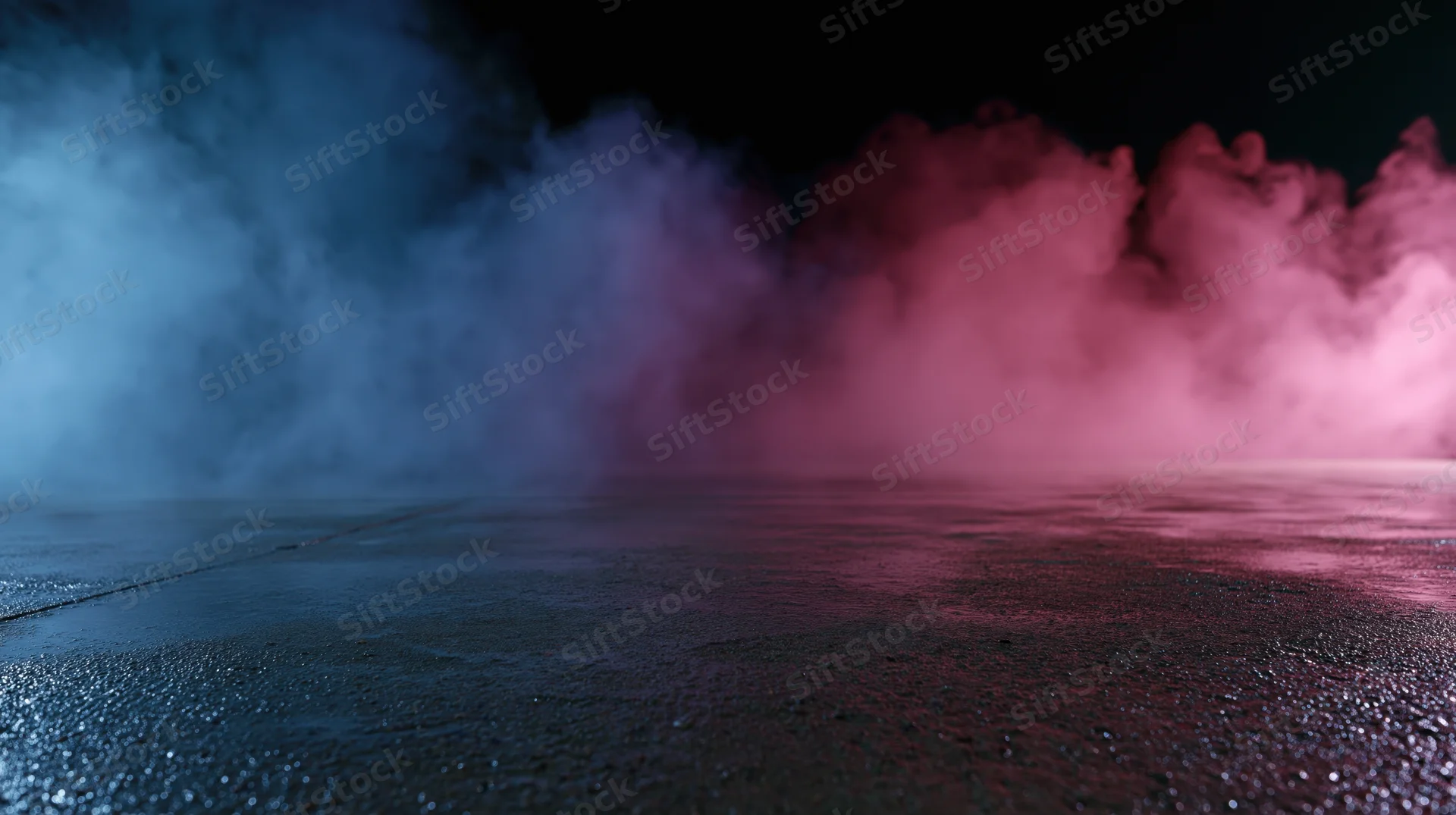 Colored smoke drifting over a wet concrete floor in a dark studio space