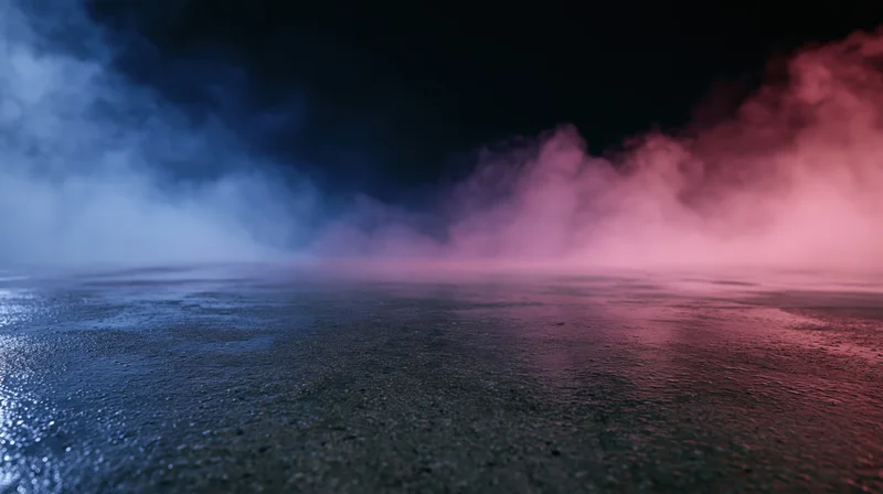 Pink and blue smoke drifting over a wet reflective surface at night