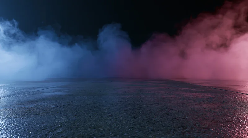 Colored smoke drifting over wet pavement at night