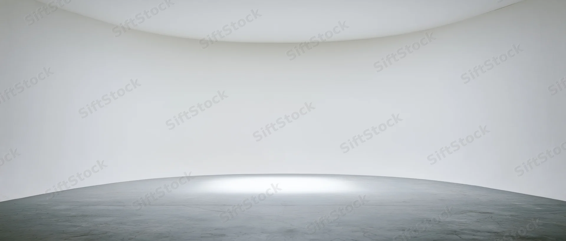 Curved white walls and smooth gray floor in an empty modern gallery space