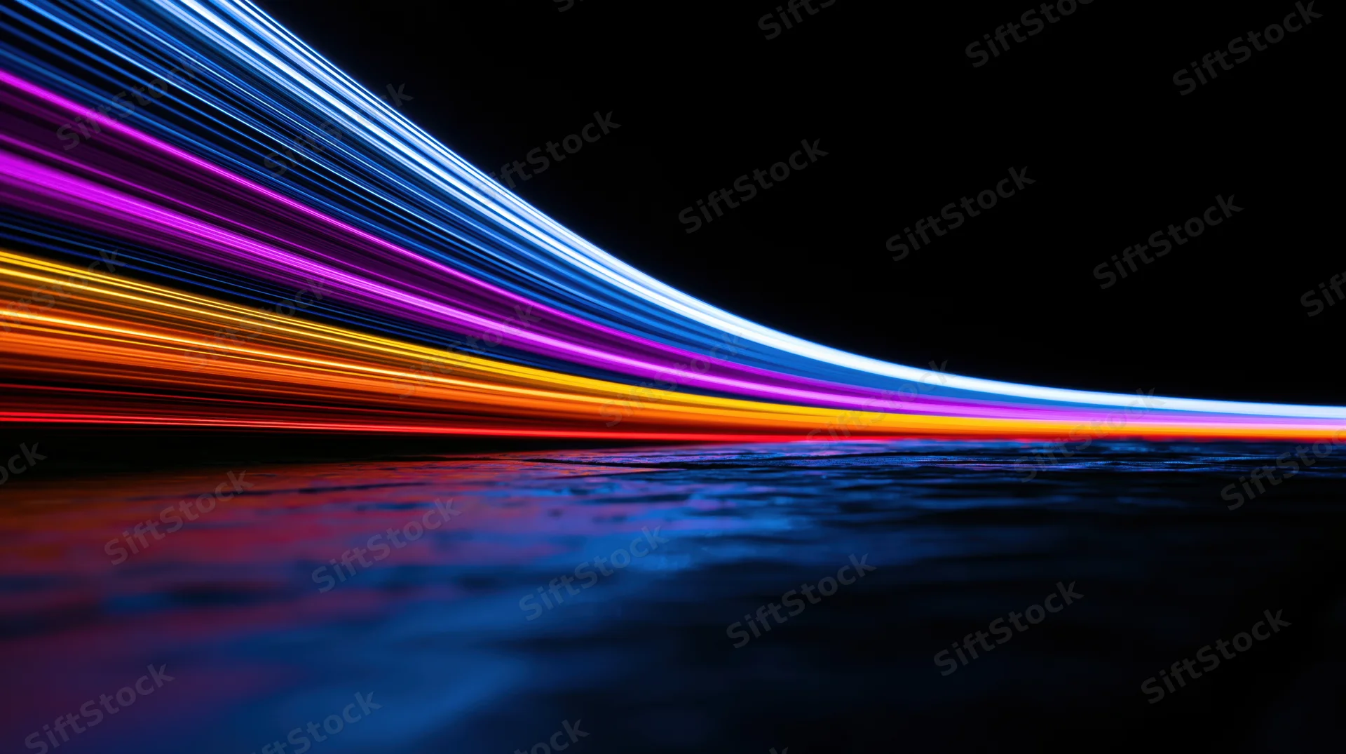 Colorful light trails curving over dark water surface at night