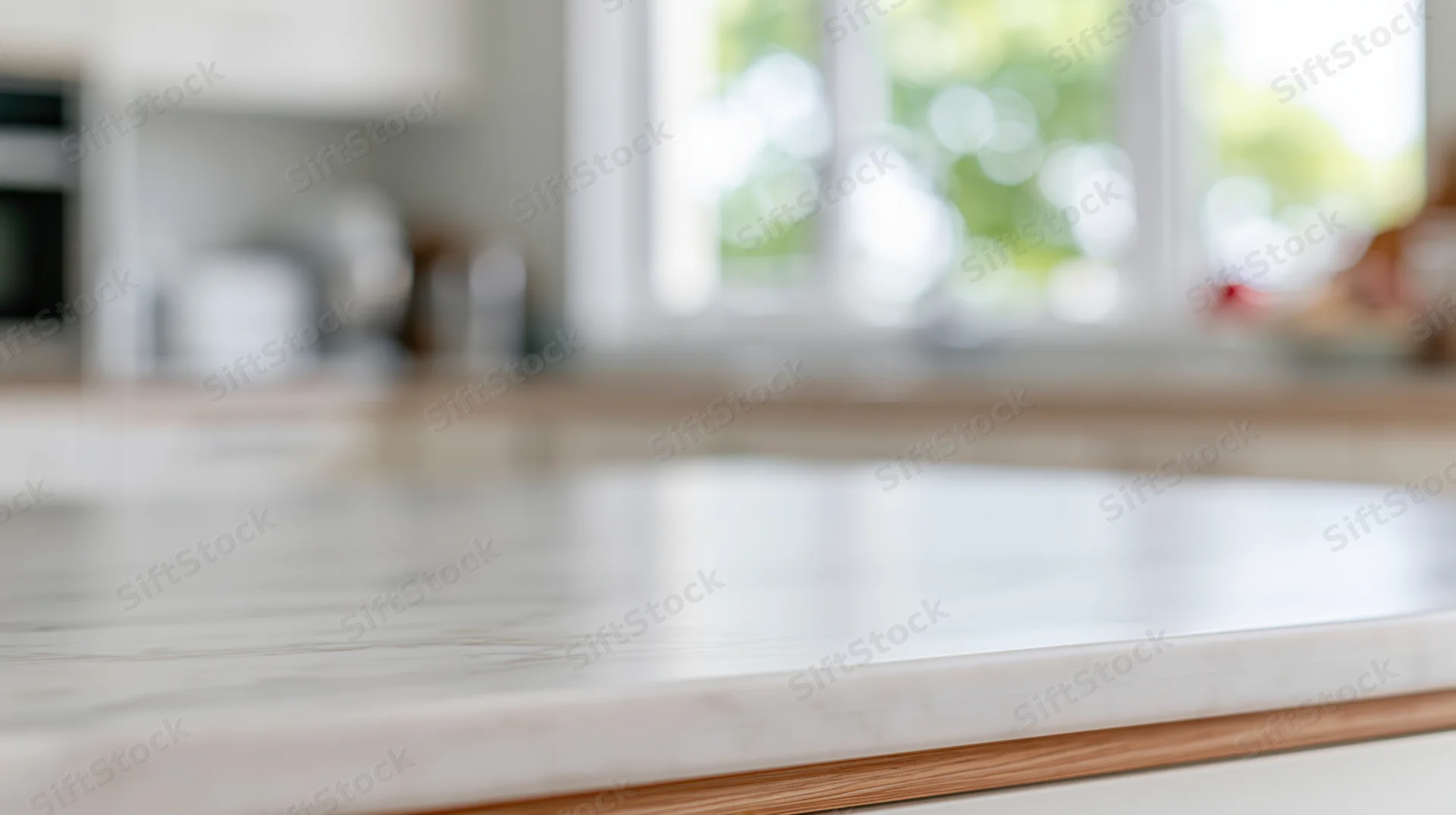 White marble kitchen countertop with wooden edge and blurred window view in background