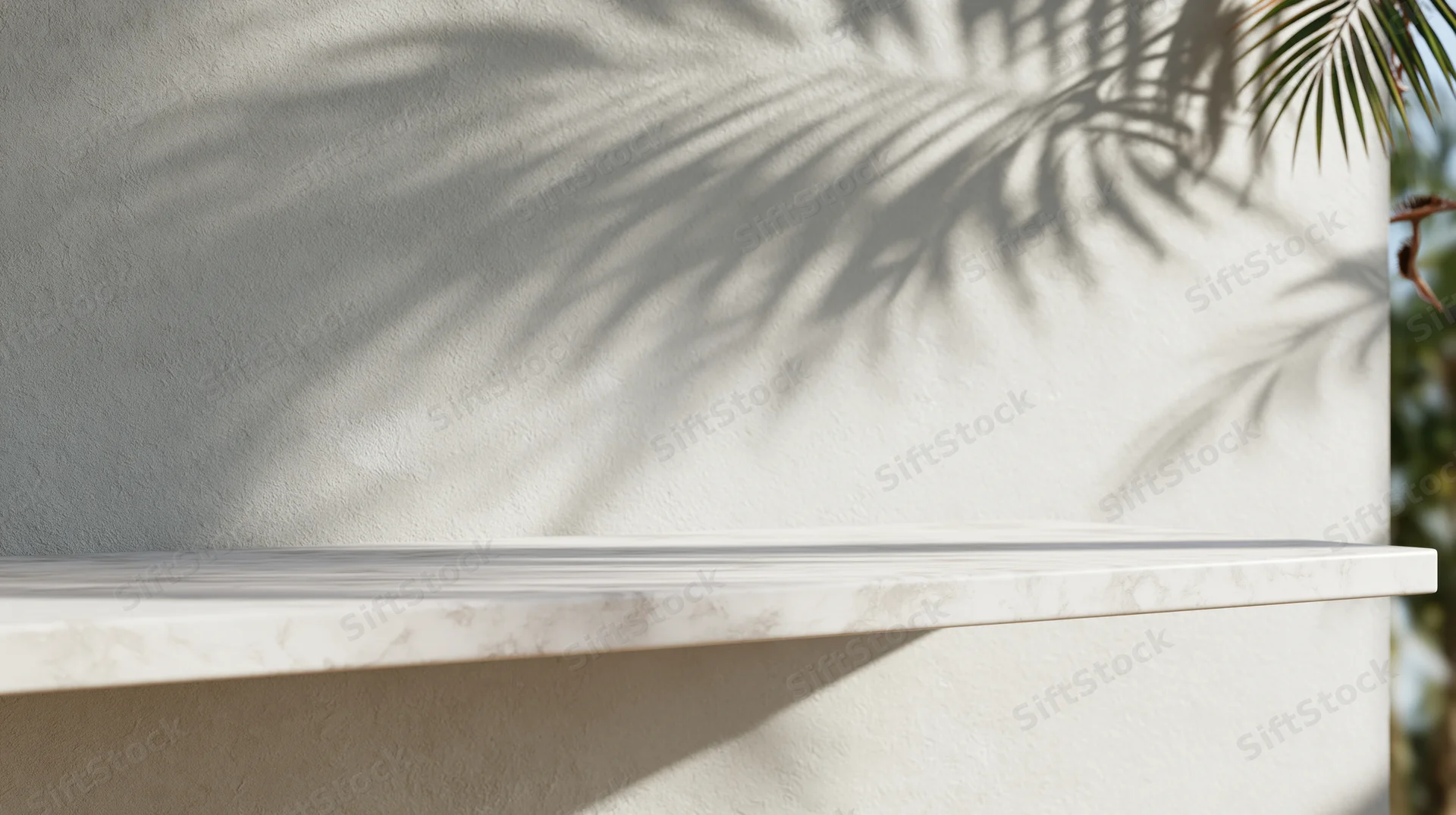 Palm shadow on white stucco wall with marble shelf outdoors