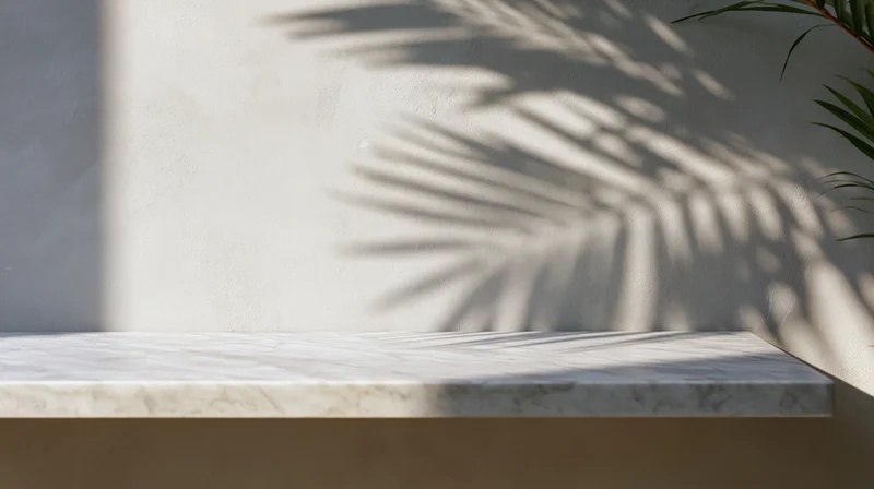 Marble shelf with palm leaf shadow on a white wall outdoors