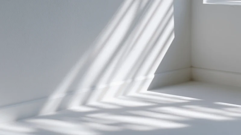 Sunlight casting striped shadows across white interior corner floor and wall