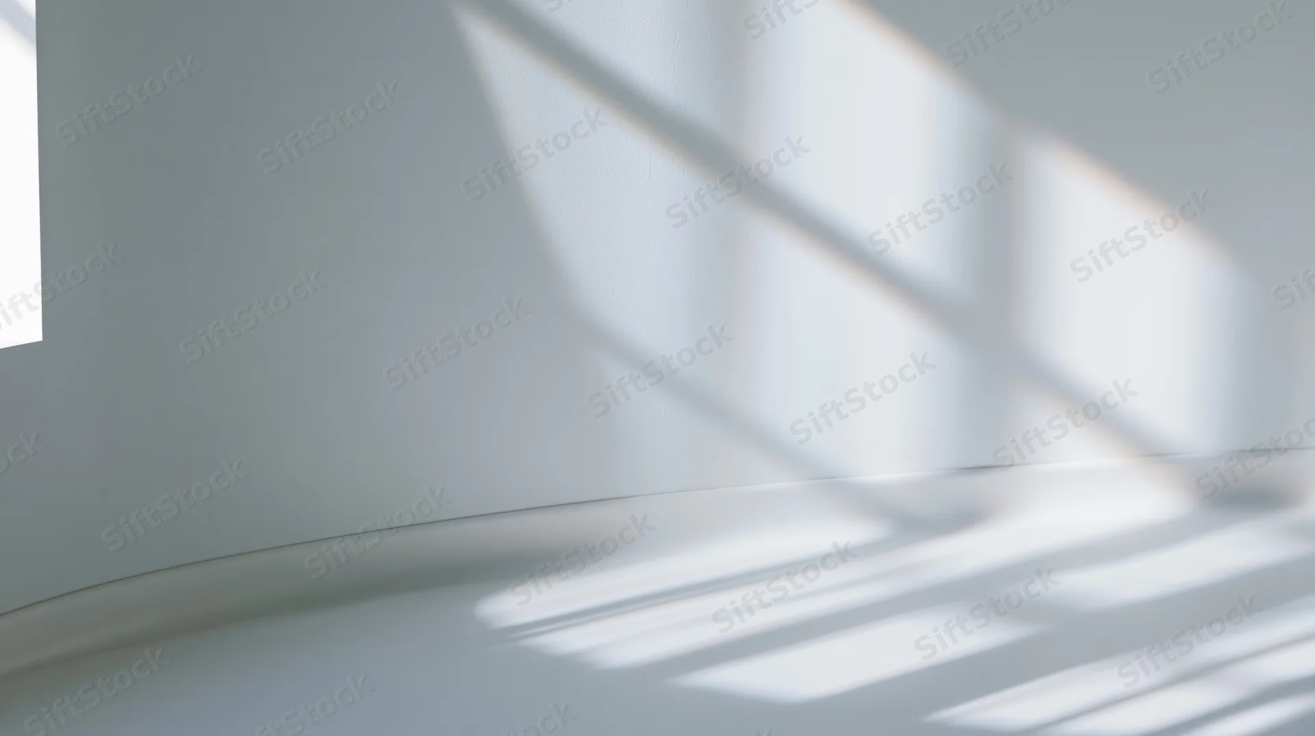 Light and shadow patterns on a white interior wall and floor