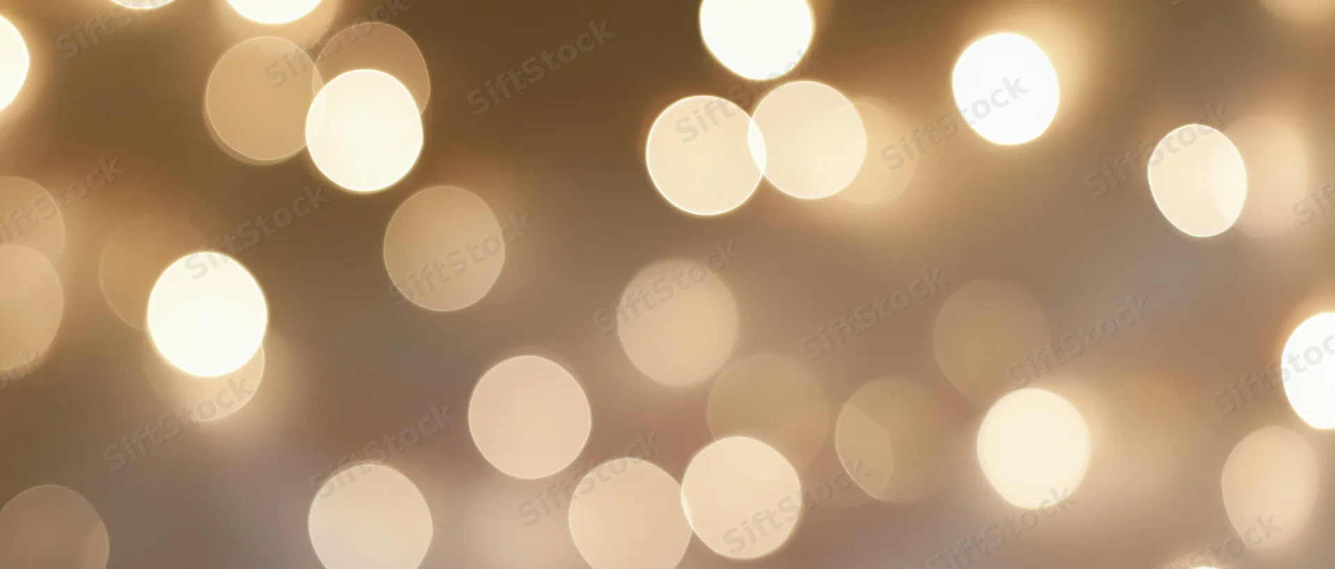 Blurred golden lights arranged in a soft bokeh pattern as a festive background