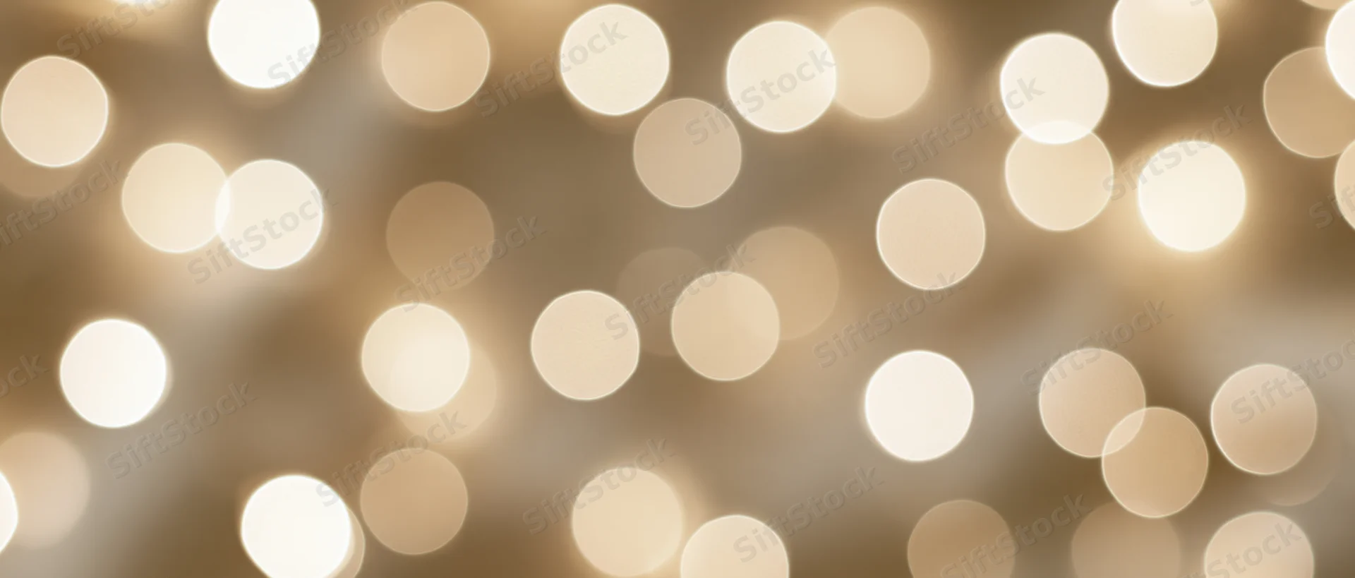 Blurred golden bokeh lights arranged as a festive background with soft glow and circular patterns