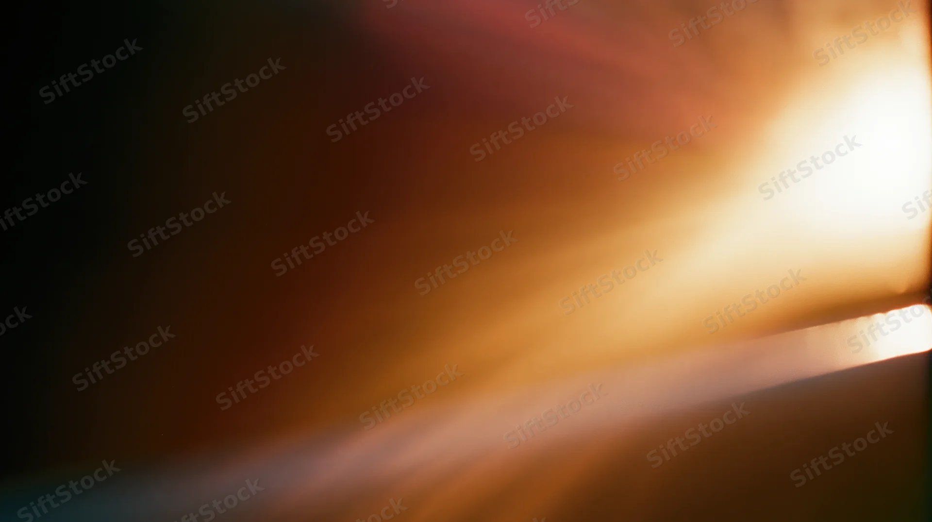 Radiant light beams glowing across a blurred horizon at sunrise or sunset