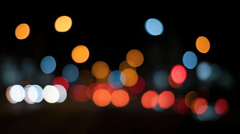 Blurred circular lights from city traffic at night forming a bokeh effect in the urban landscape
