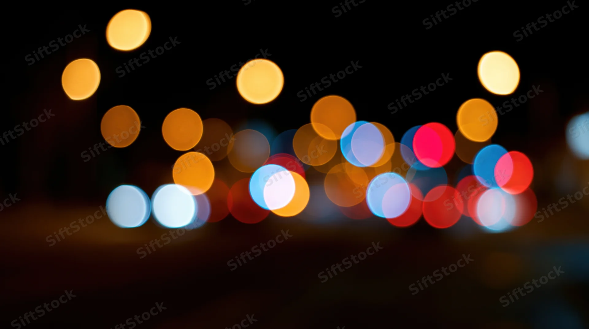 Blurred circular lights from vehicles and street lamps in a city at night