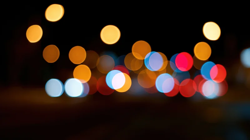 Blurred circular lights from vehicles and street lamps in a city at night