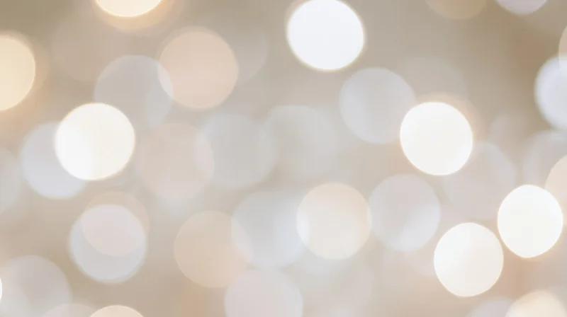 Blurred circular lights creating a soft glowing background with warm beige tones and festive ambiance