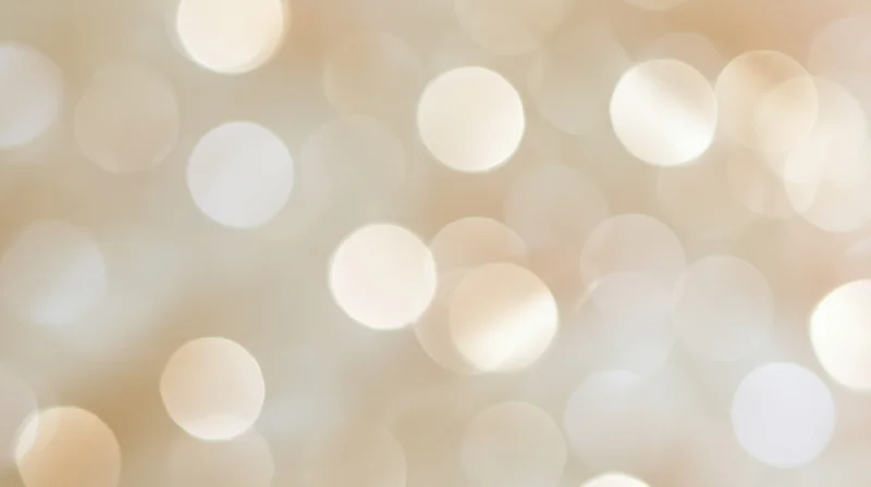 Soft glowing bokeh lights in warm beige and white tones filling the frame as a decorative background