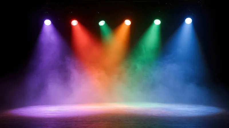 Colorful spotlights illuminating a smoky stage floor in a performance venue