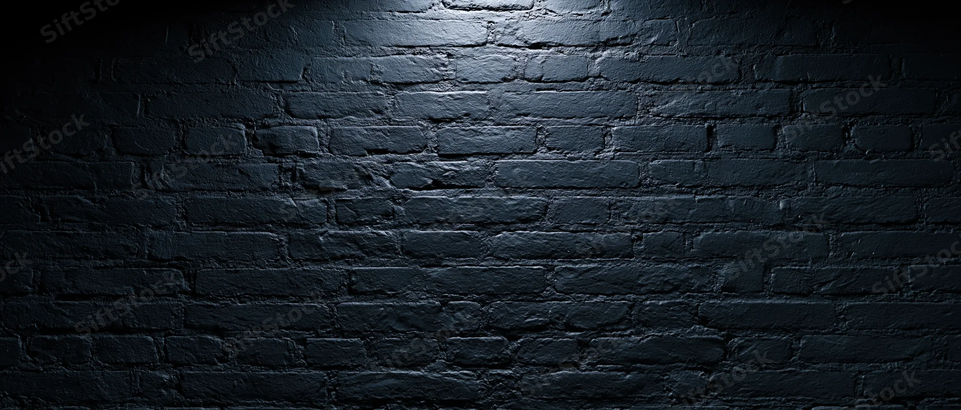 Dark brick wall illuminated by spotlight with shadows and copyspace