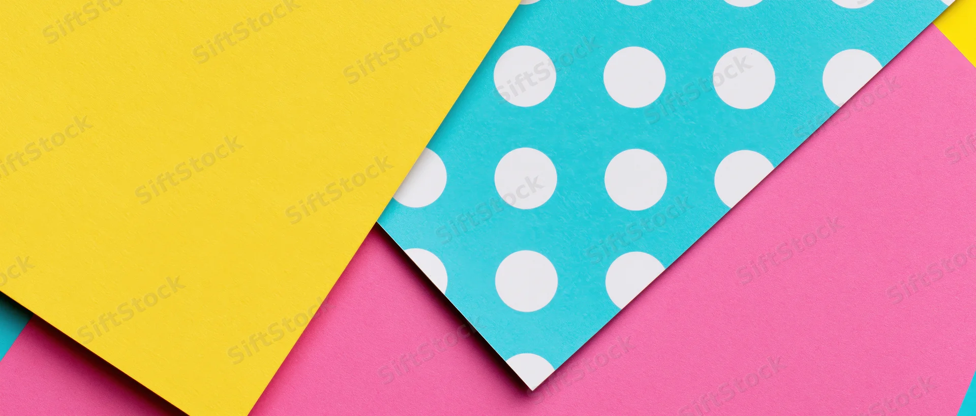 Colorful patterned paper sheets arranged in overlapping diagonal layers on flat surface