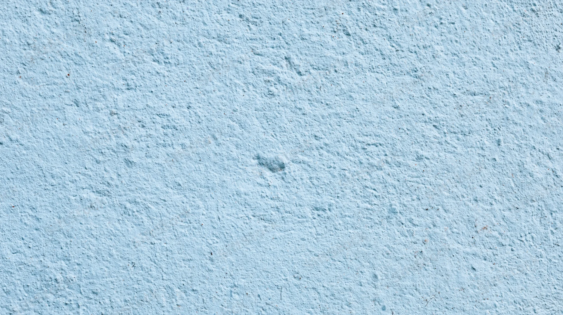 Light blue textured wall surface with rough plaster finish