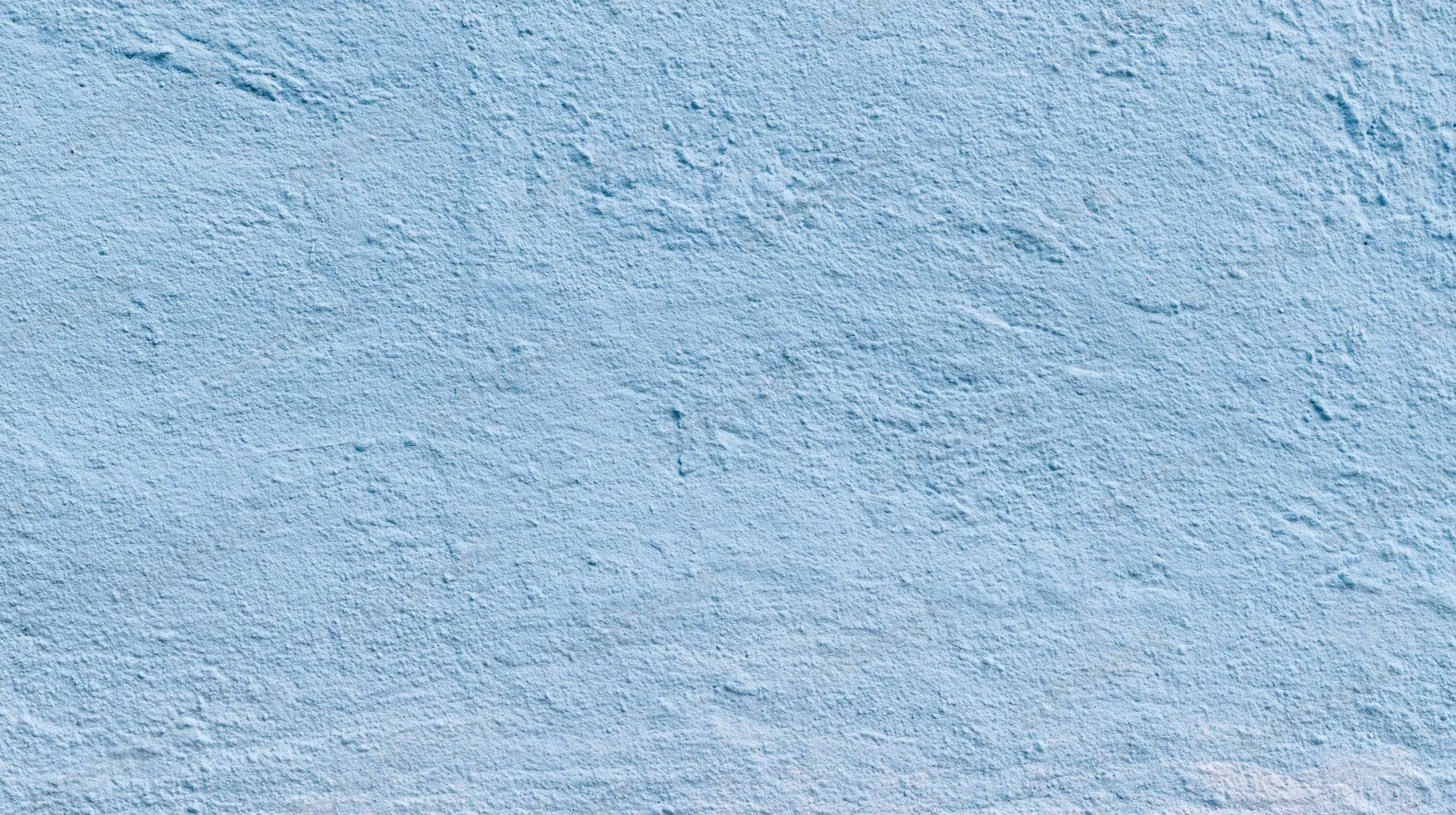 Light blue textured wall surface with subtle grain and even tone