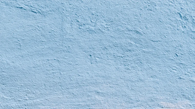 Light blue textured wall surface with subtle grain and even tone