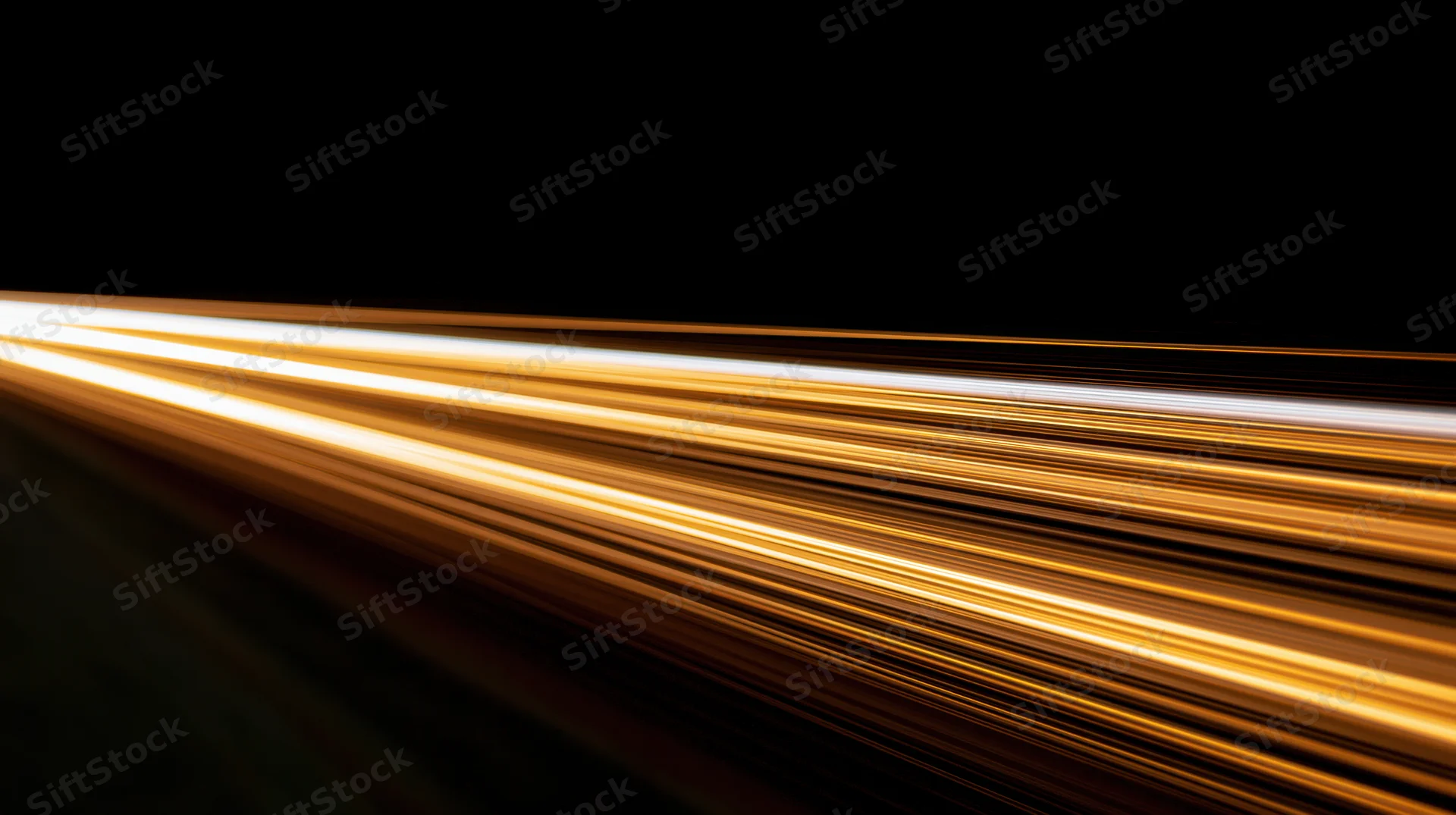Golden light streaks from moving vehicles on a dark road at night