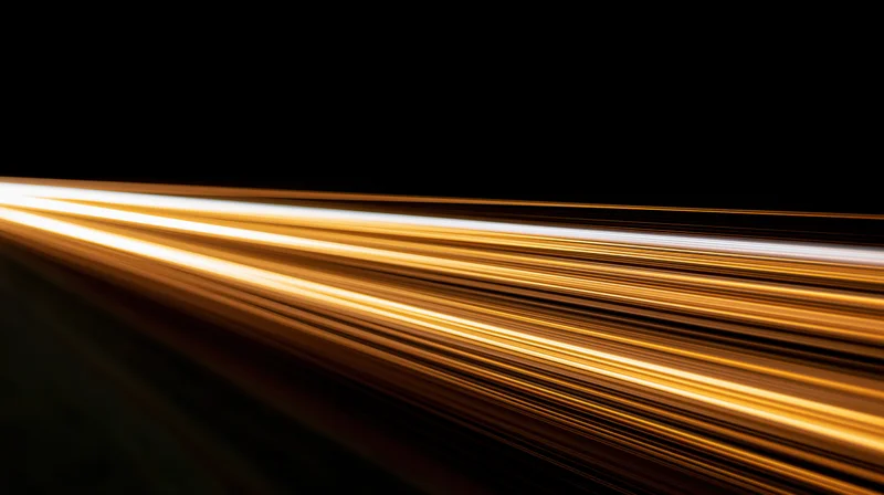 Golden light streaks from moving vehicles on a dark road at night