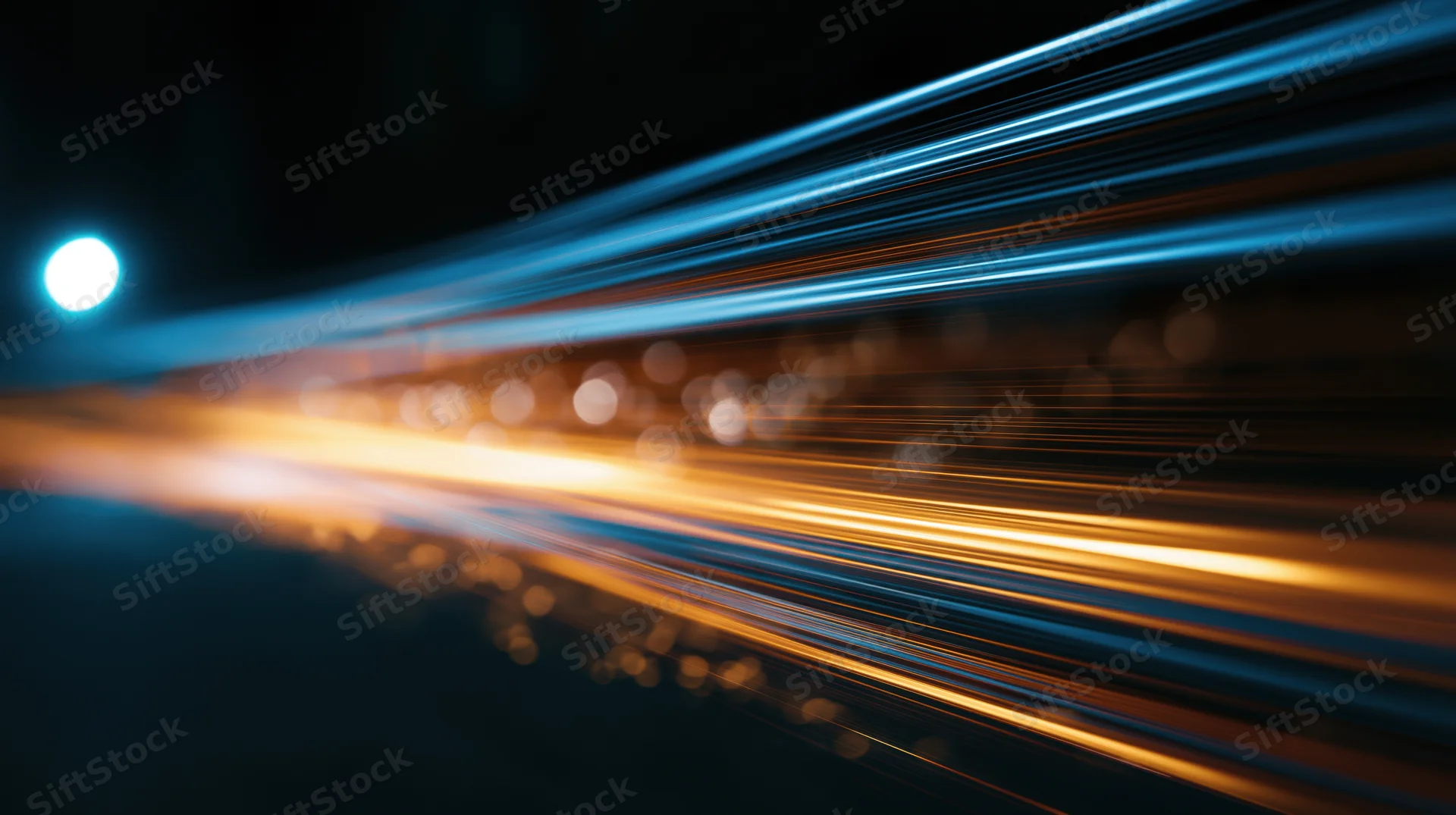 Streaks of light from moving vehicles on a dark road at night