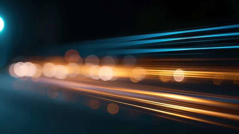 Streaks of orange and blue light moving across a dark background with bokeh highlights