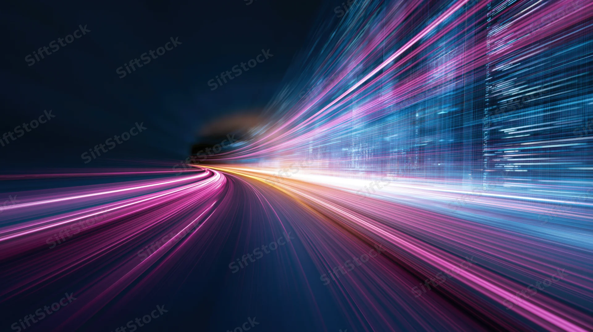 Light streaks from moving vehicles at night in a cityscape, creating abstract motion trails along a curved road