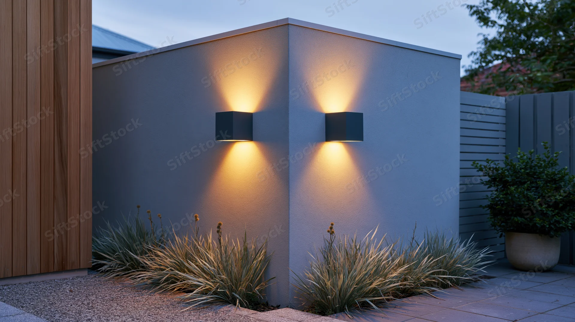 Modern outdoor wall sconces illuminating a garden patio at dusk