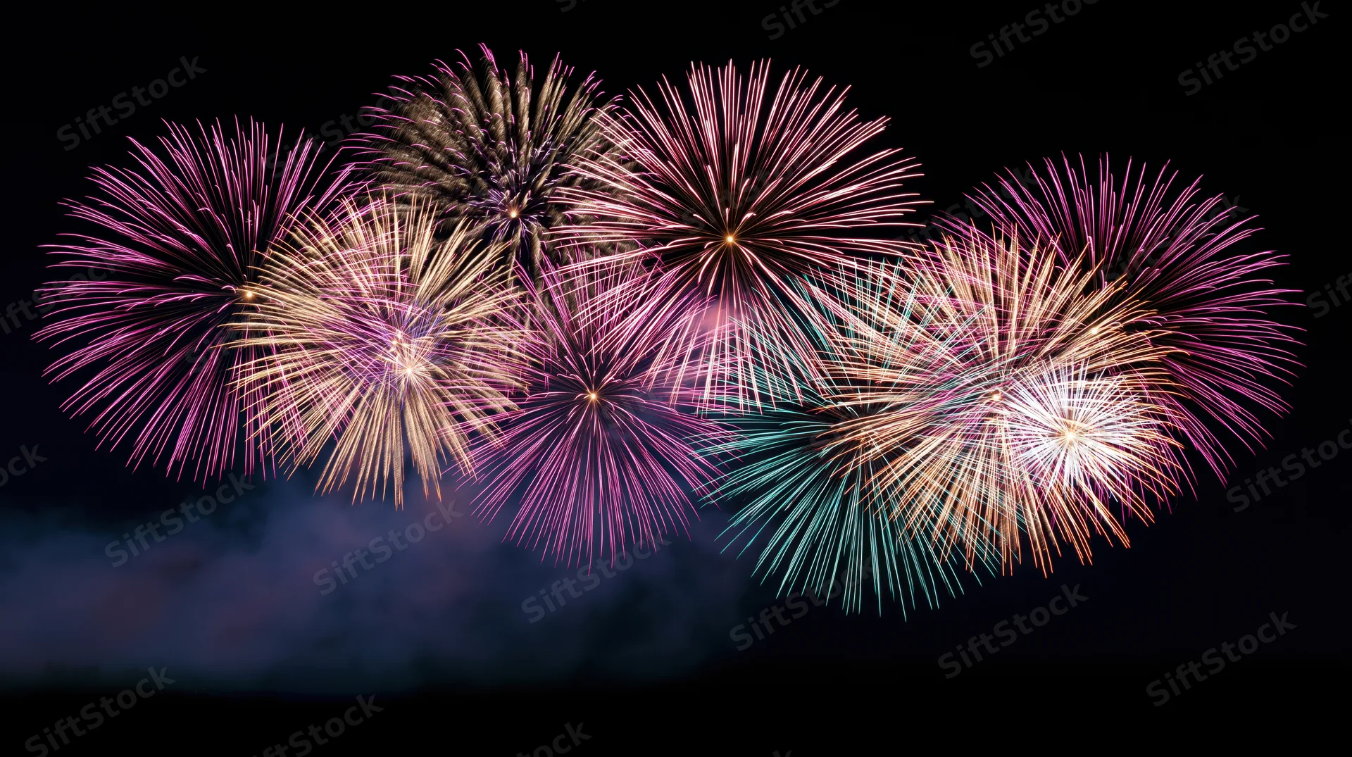 Fireworks bursting in vibrant colors across the night sky during a celebration