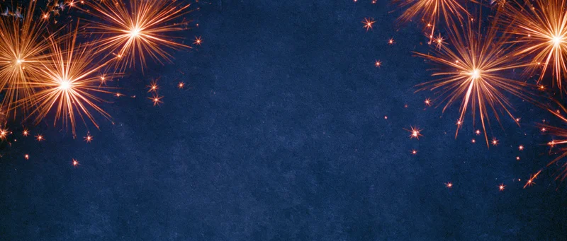 Fireworks exploding in the night sky with bright orange sparks against a dark blue background, leaving copyspace in the center
