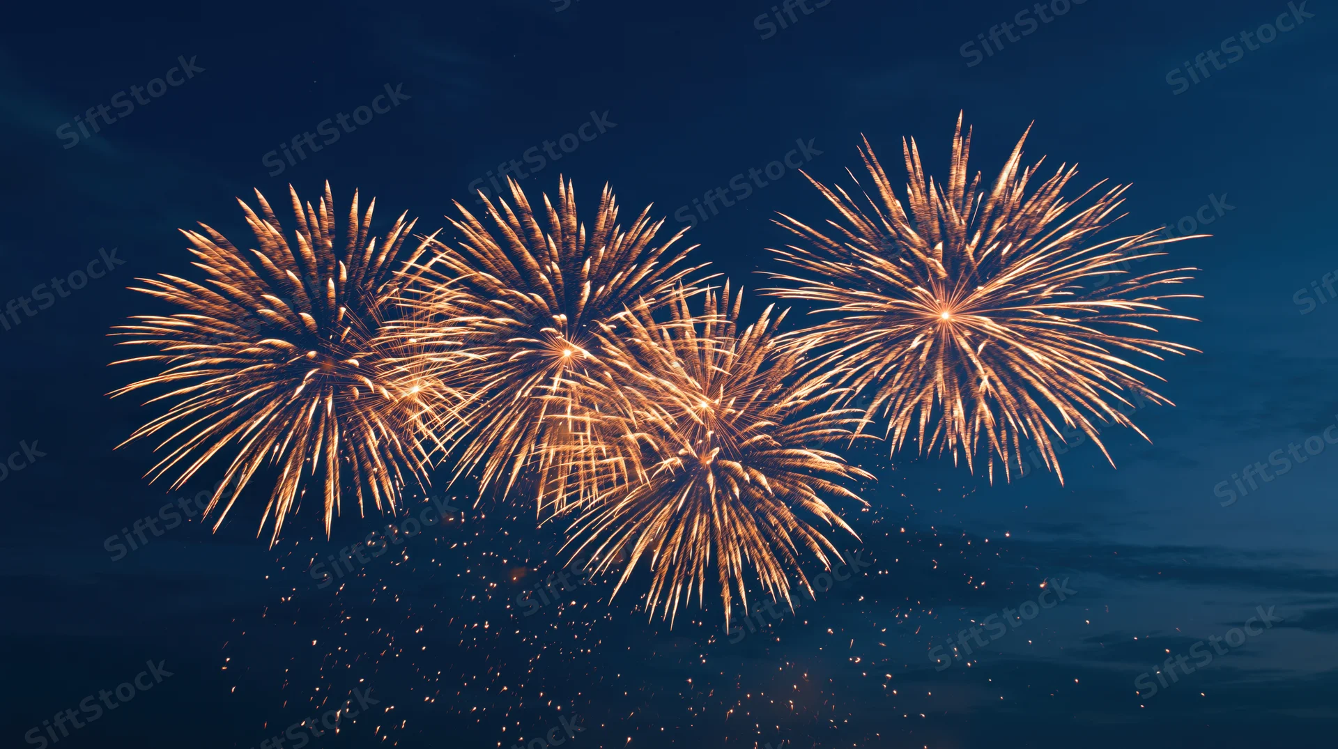 Golden fireworks exploding in the dark night sky during a celebration