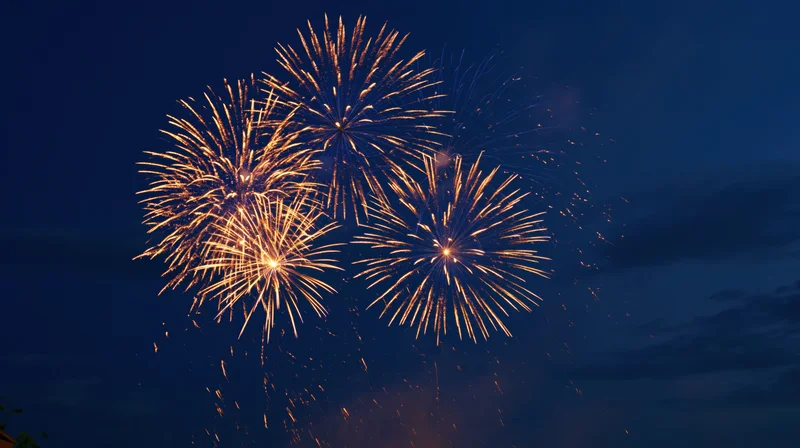 Golden fireworks bursting in the dark night sky during a celebration