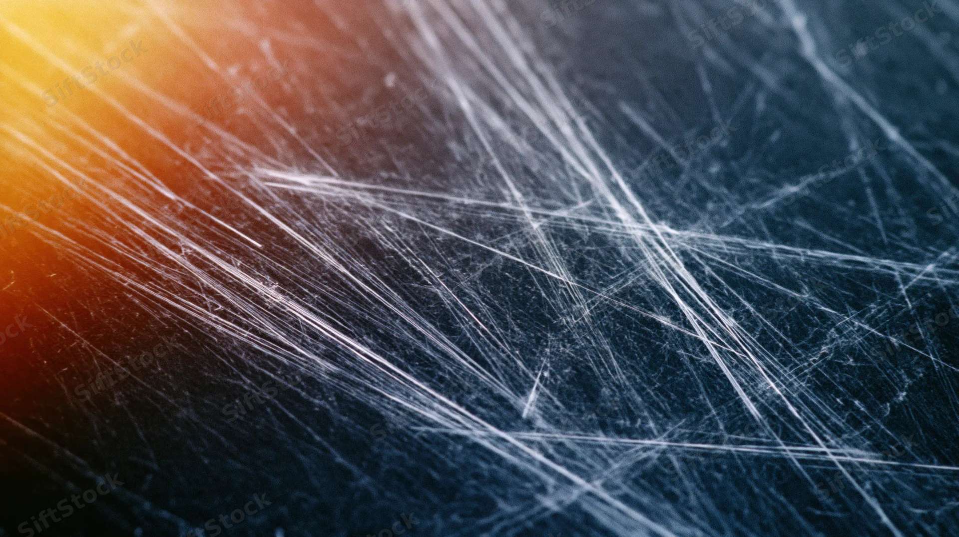 Abstract scratched surface with intersecting white lines and warm-to-cool color gradient