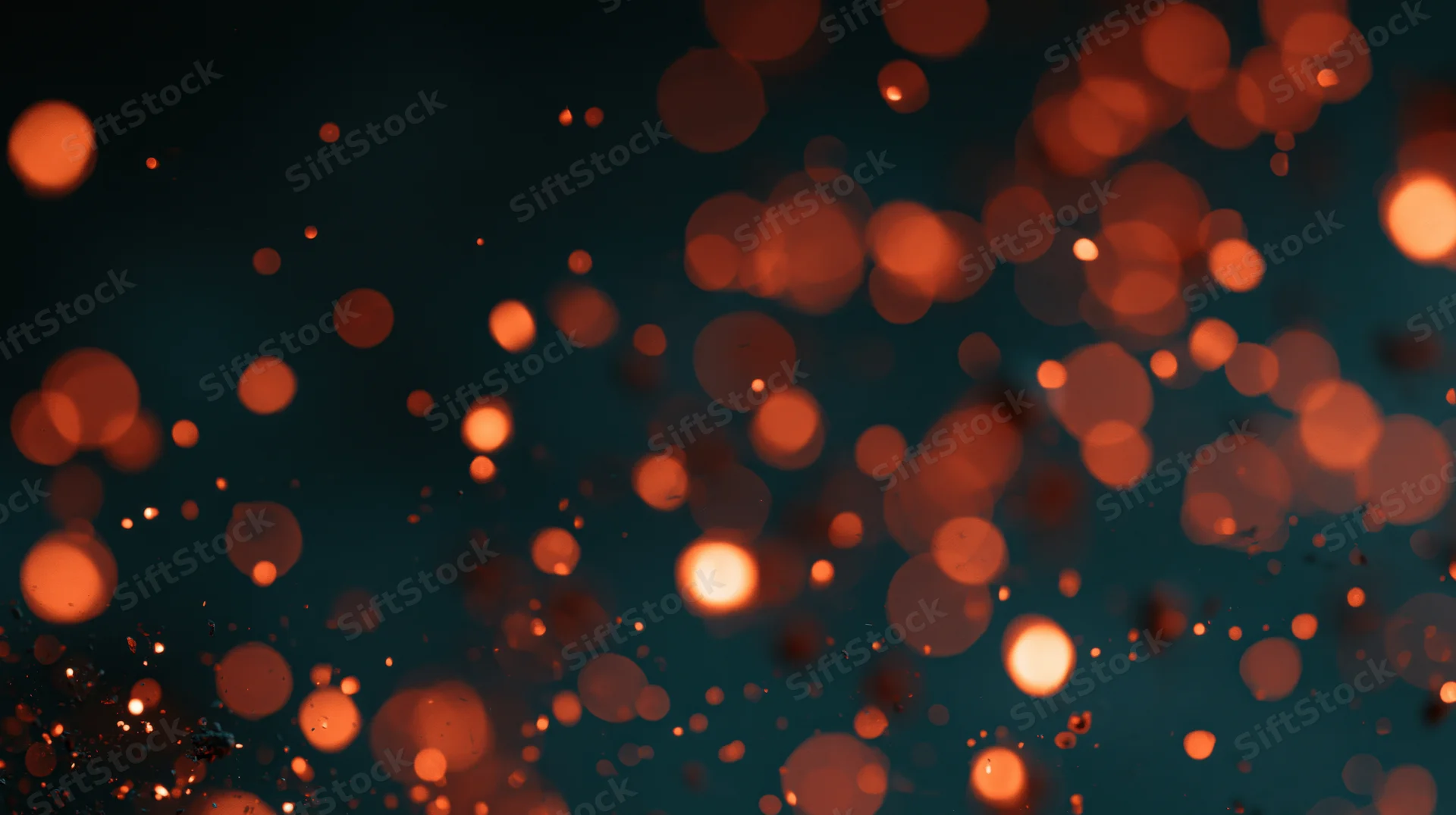 Glowing orange bokeh lights scattered across a dark background