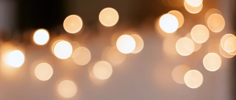 Blurred warm circular lights arranged in a string as decorative illumination for festive occasions