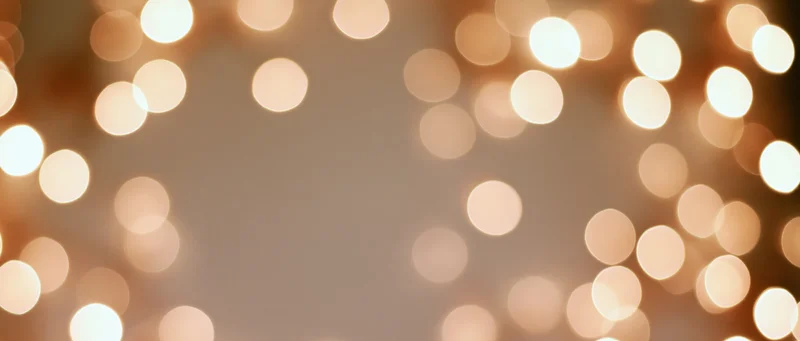 Warm golden bokeh lights arranged in a frame around a central copyspace