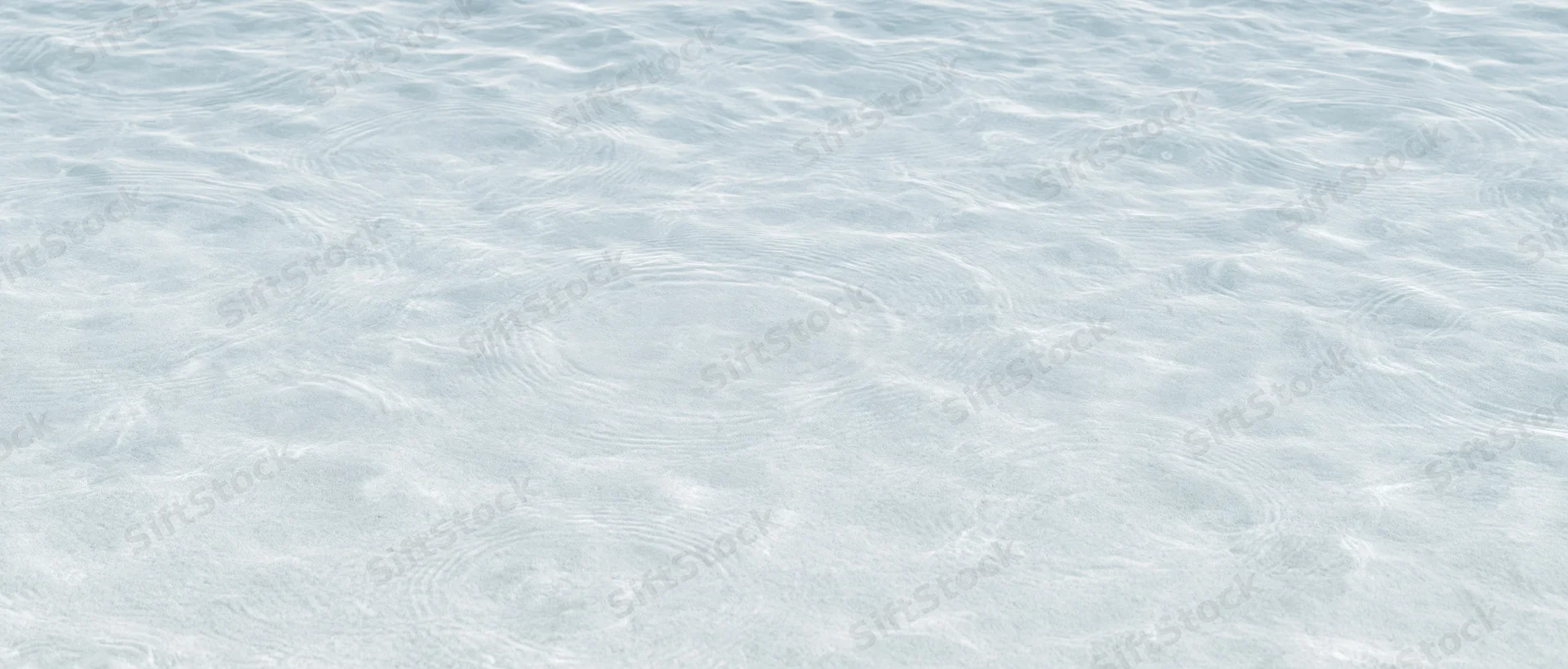 Calm rippling water surface over sandy bottom in shallow clear ocean