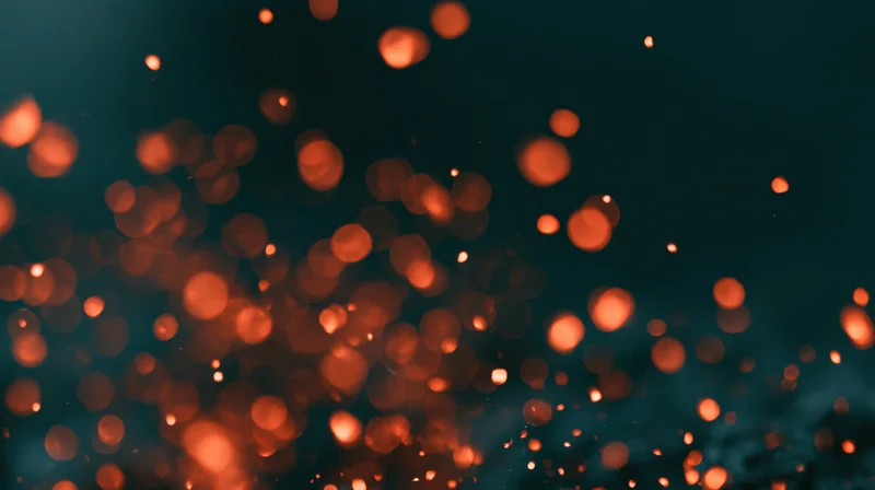 Floating orange bokeh lights against a dark blue background with soft glow and motion blur