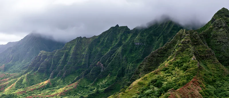 Rugged green mountains with misty peaks and dense vegetation in a tropical valley