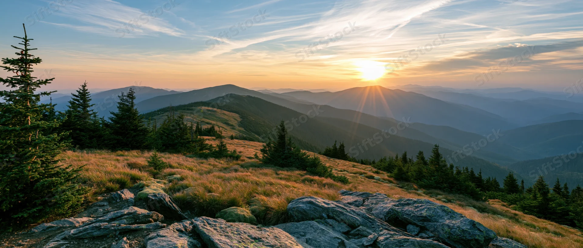 Sunrise over mountain ridge with pine trees and rocky meadow in alpine landscape