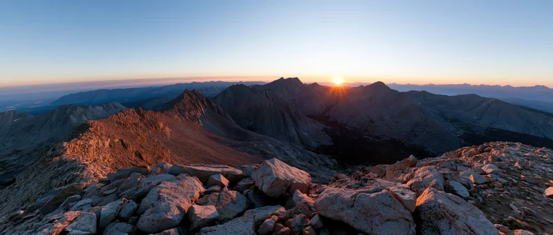 Sunrise over rugged mountain peaks and rocky terrain in alpine landscape